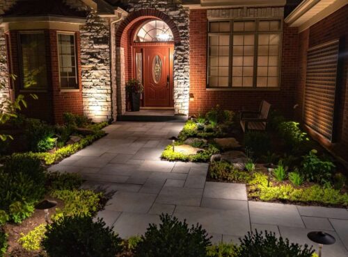 Evening view of a lit driveway and entry